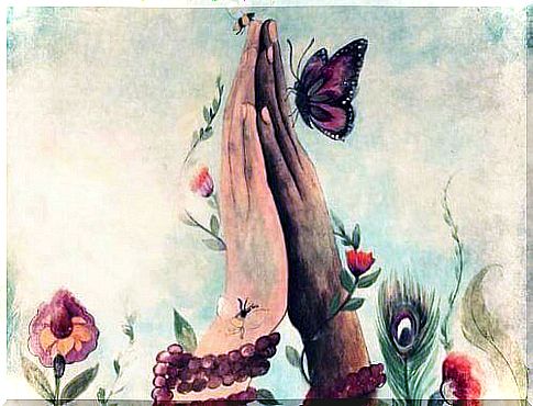 Folded hands among butterflies and flowers