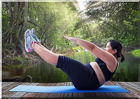 An obese woman is exercising on a mat