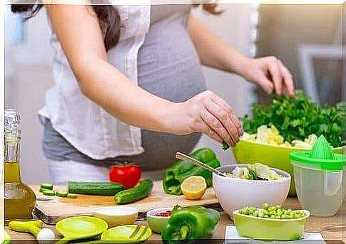 Pregnant woman preparing a salad - taking folic acid during pregnancy