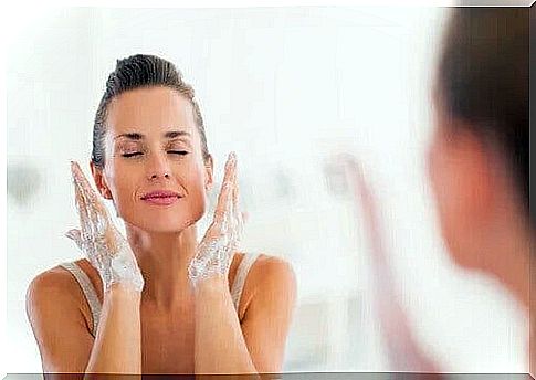 The woman is washing her face