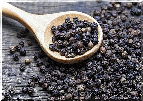 Black pepper on a wooden spoon